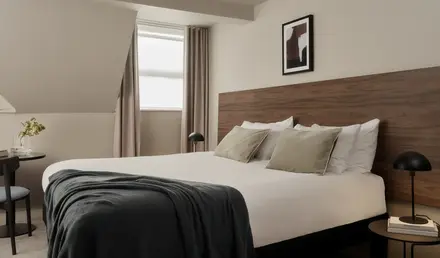 a bed with a black blanket and a wood headboard