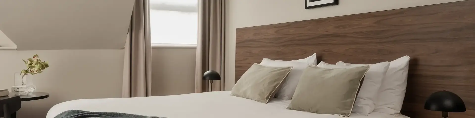 a bed with a black blanket and a wood headboard