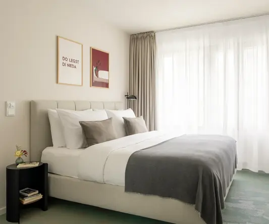 a bed with pillows and a lamp in a room with curtains