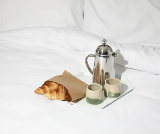 a tray of breakfast items on a bed