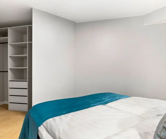 a room with a bed and shelves