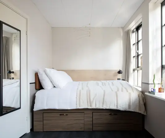 a bed with white sheets and pillows