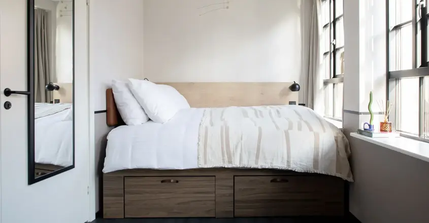 a bed with white sheets and pillows