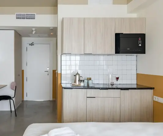 a room with a bed and kitchen