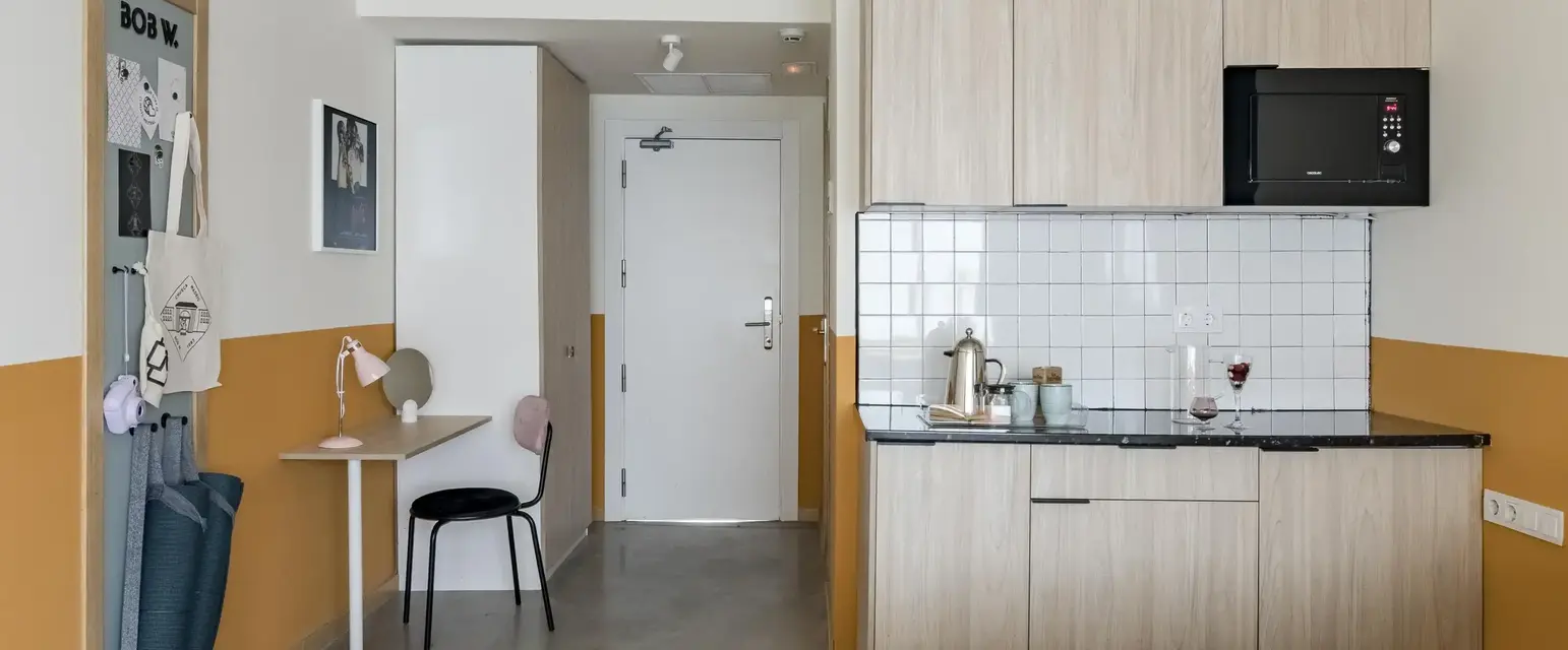 a room with a bed and kitchen