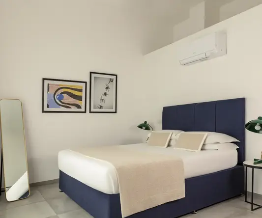 a bed with a blue headboard and a mirror