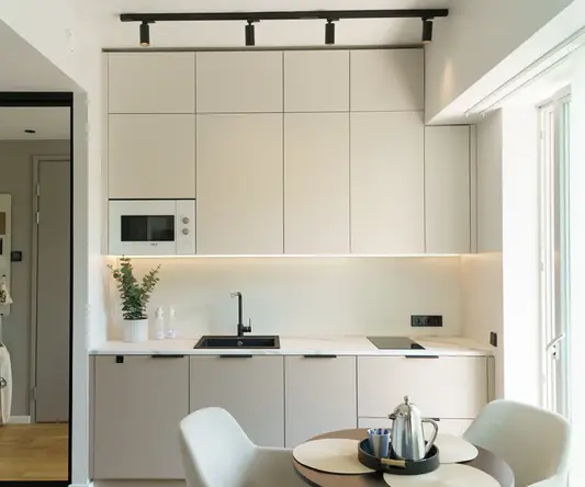 a kitchen with white cabinets and a table
