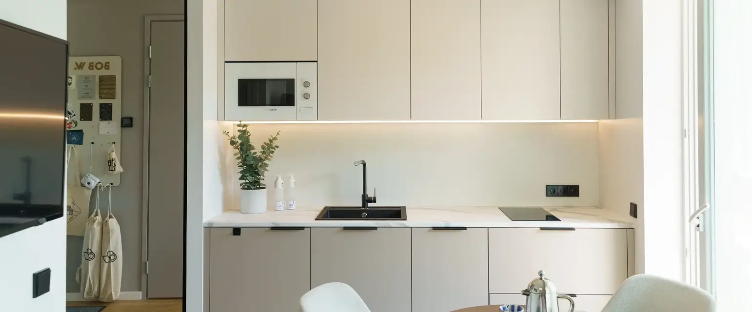 a kitchen with white cabinets and a table
