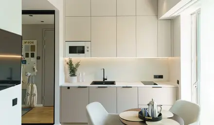 a kitchen with white cabinets and a table