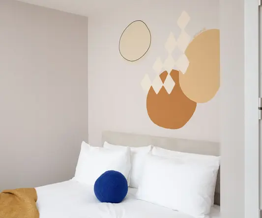 a bed with pillows and a ball on it