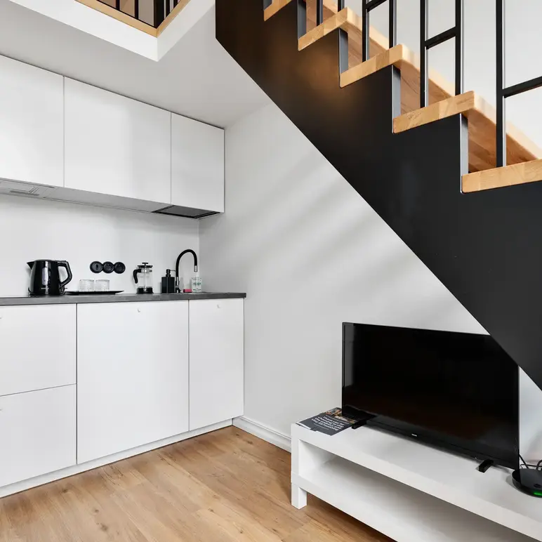 a staircase with a tv and a coffee maker