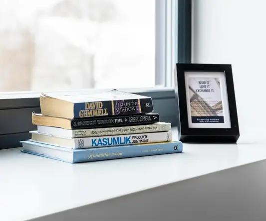 a stack of books on a window sill