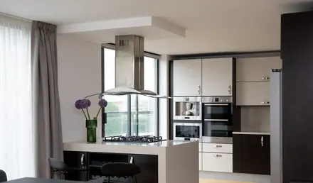 a kitchen with a stove and a flower vase