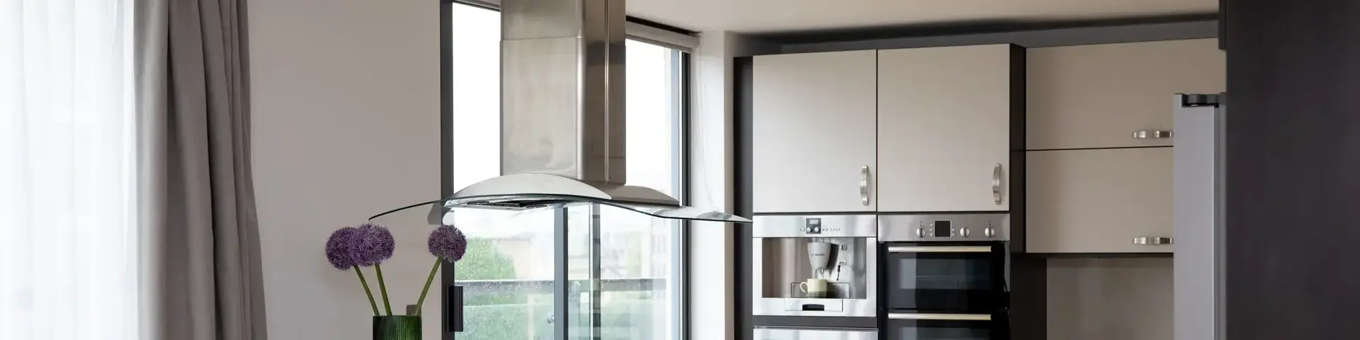 a kitchen with a stove and a flower vase