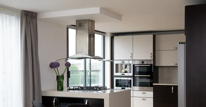 a kitchen with a stove and a flower vase