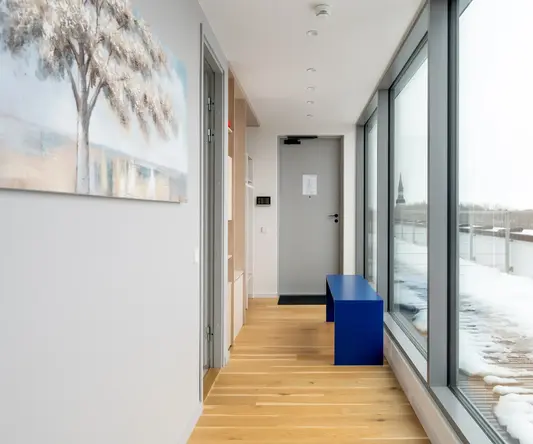 a hallway with a blue bench and a wood floor
