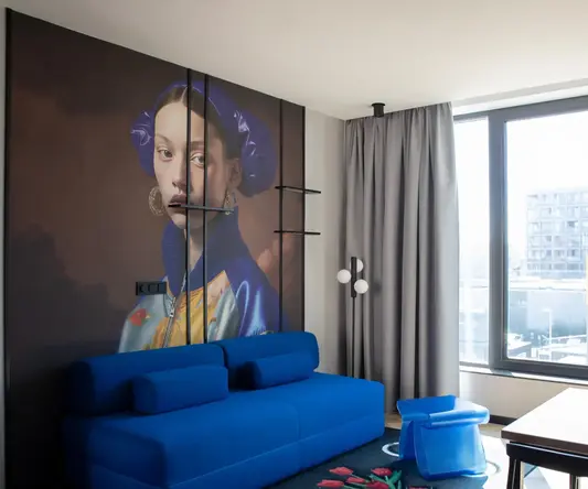 a room with a couch and a painting on the wall