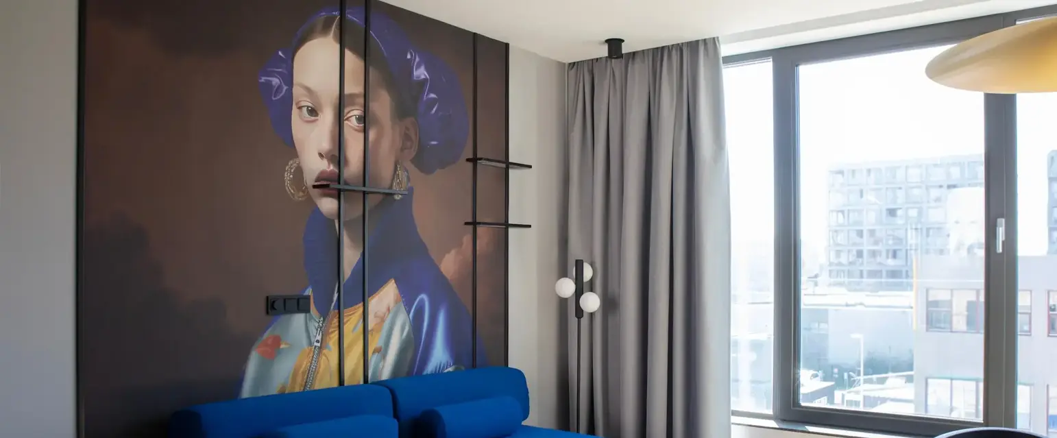 a room with a couch and a painting on the wall