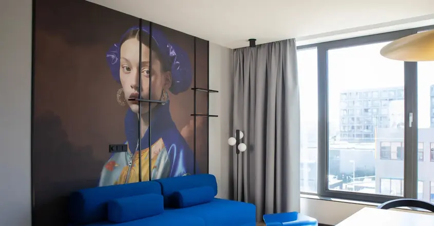 a room with a couch and a painting on the wall