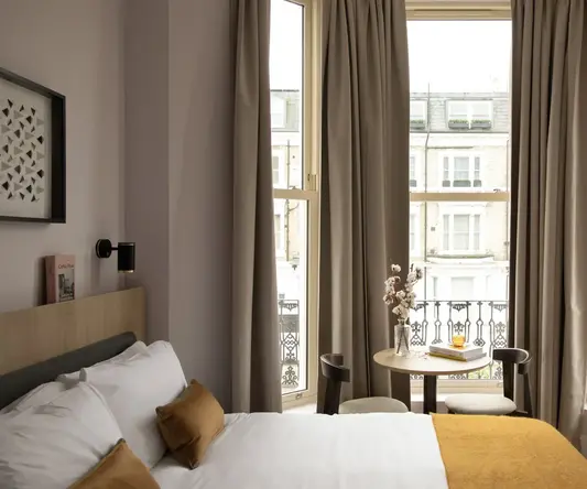 a room with a bed and a table and chairs