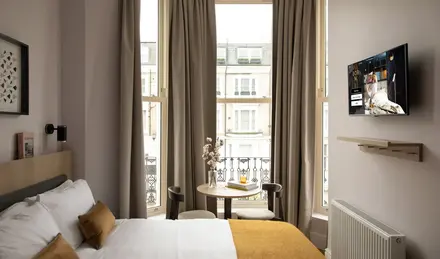 a room with a bed and a table and chairs