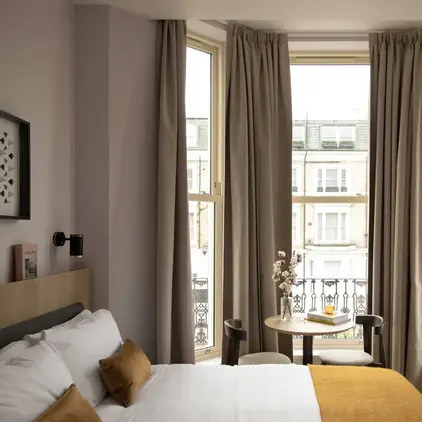 a room with a bed and a table and chairs