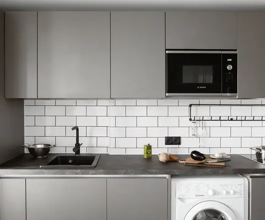 a kitchen with a microwave and a washing machine