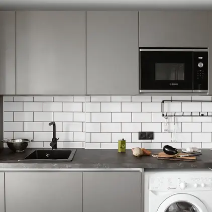 a kitchen with a microwave and a washing machine