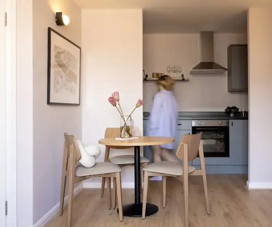 a woman walking in a kitchen