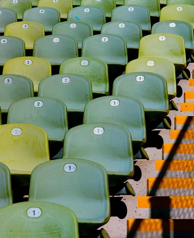 a rows of green and yellow stadium seats