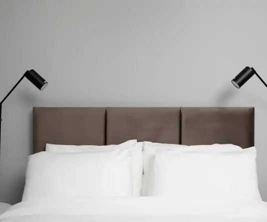 a bed with a headboard and two lamps