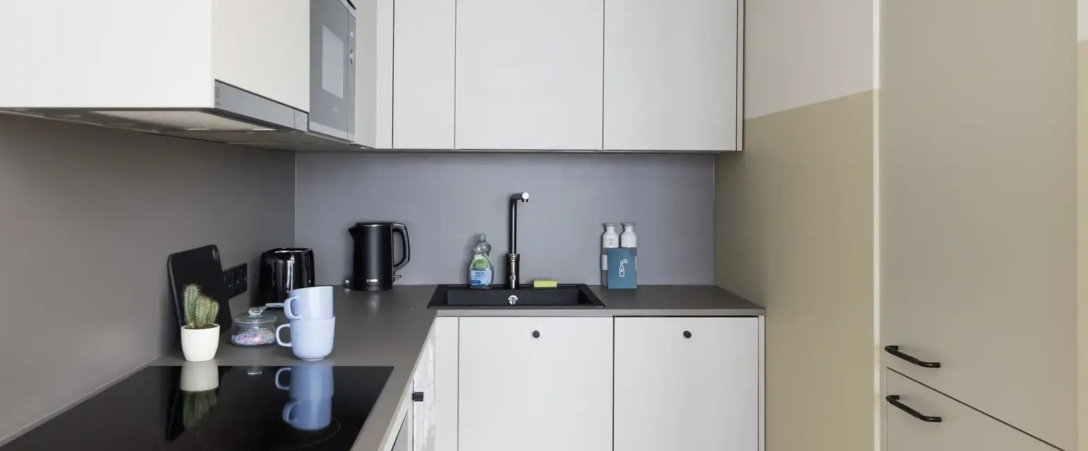a kitchen with white cabinets and black counter tops