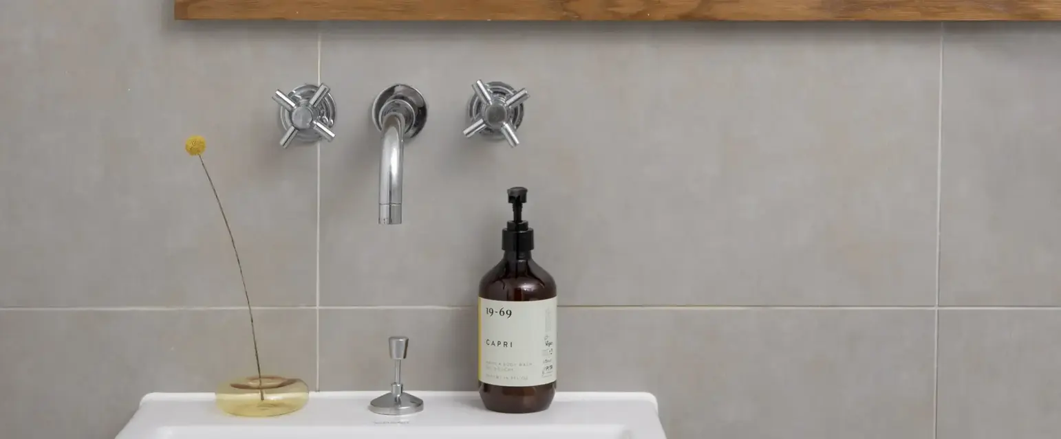 a sink with a bottle and faucet