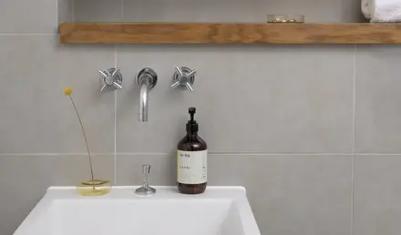 a sink with a bottle and faucet