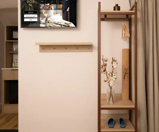 a shelf with shoes and a tv on the wall