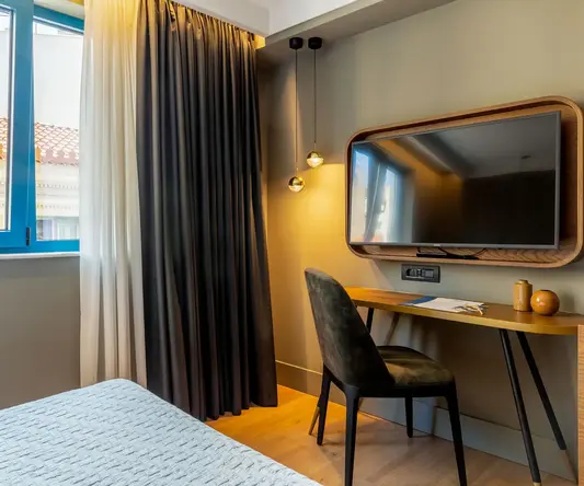 a room with a bed and a desk and a mirror