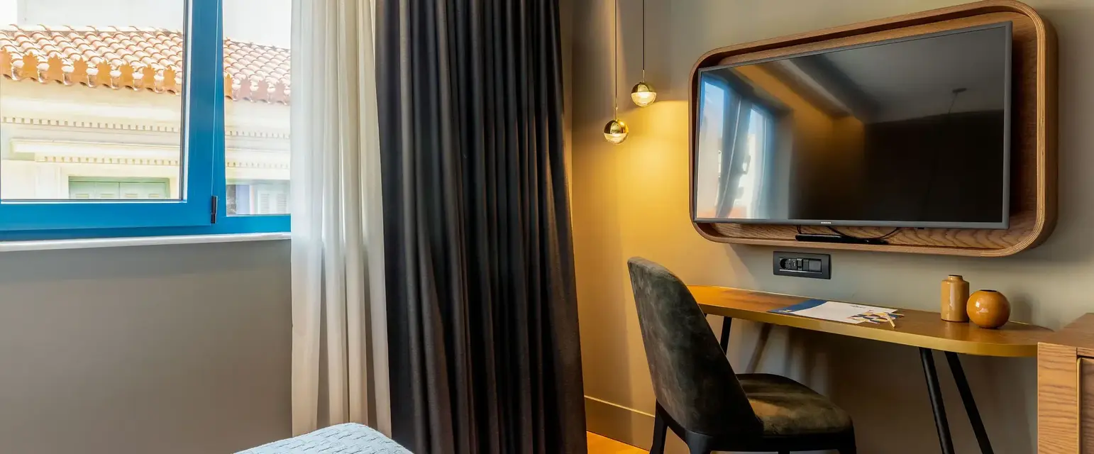 a room with a bed and a desk and a mirror