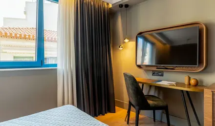 a room with a bed and a desk and a mirror