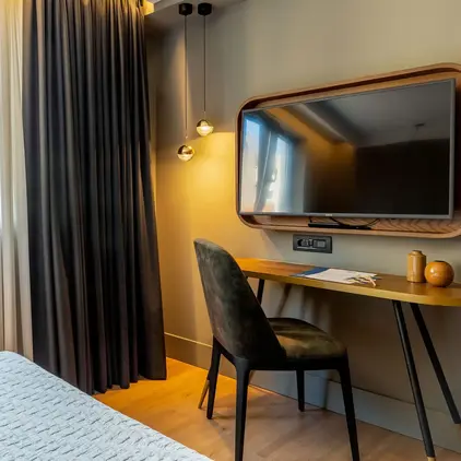 a room with a bed and a desk and a mirror