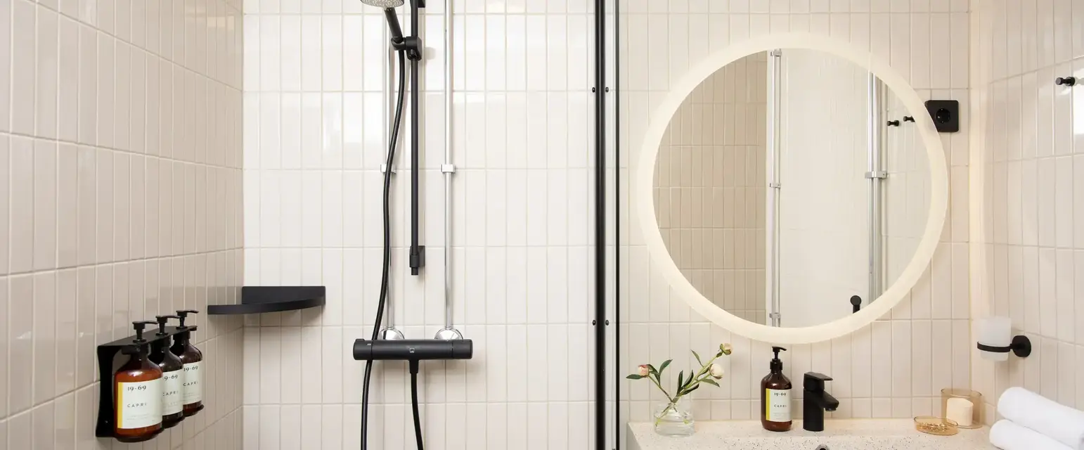 a bathroom with a round mirror and a sink