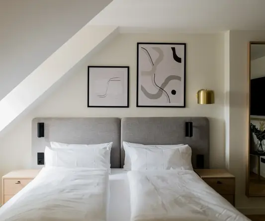 a bed with white sheets and pillows