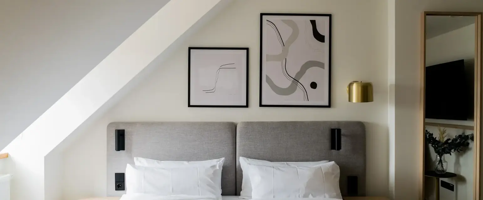 a bed with white sheets and pillows