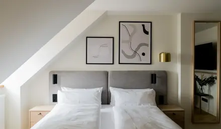 a bed with white sheets and pillows