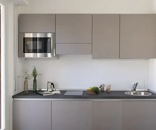 a kitchen with grey cabinets and a microwave