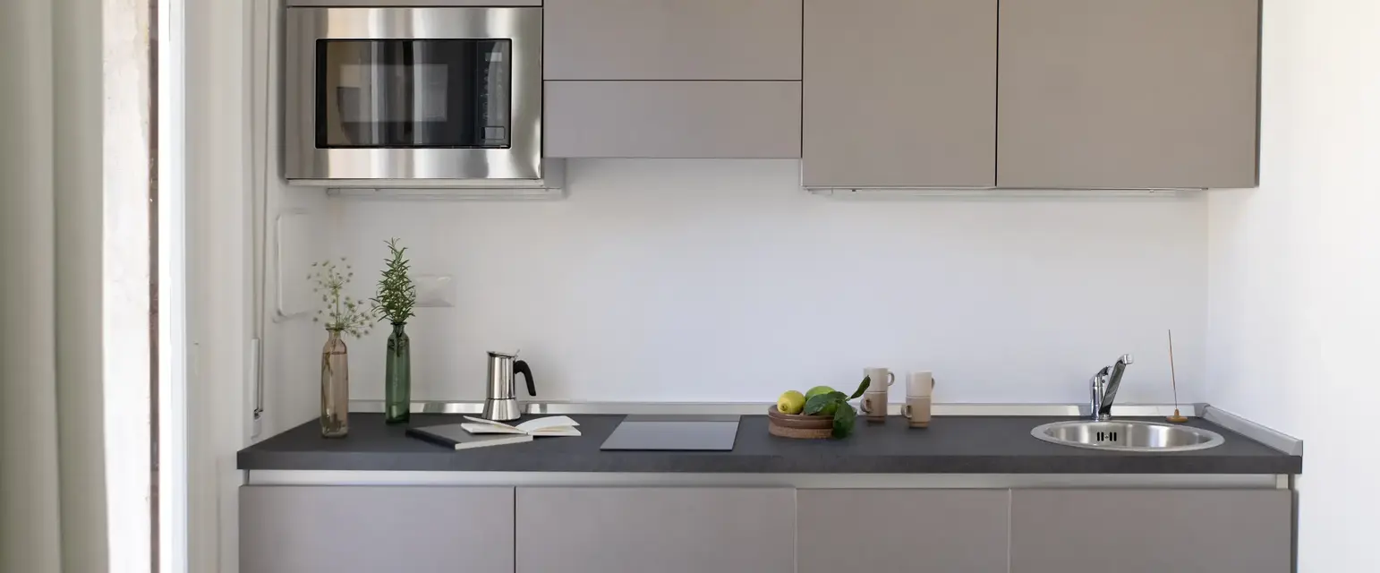 a kitchen with grey cabinets and a microwave
