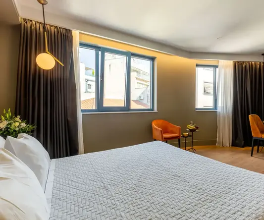 a bedroom with a bed and chairs