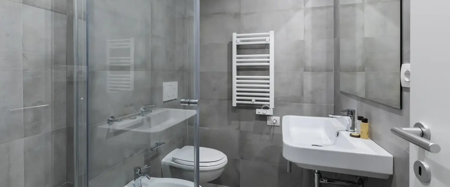 a bathroom with a glass shower door and toilet
