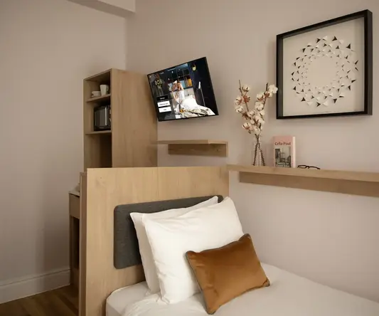 a bed with a tv mounted on the wall