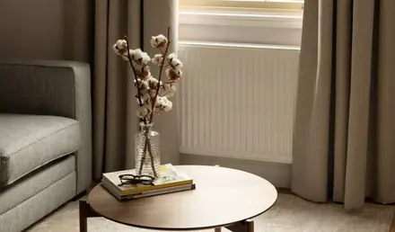 a table with a vase of cotton flowers on it