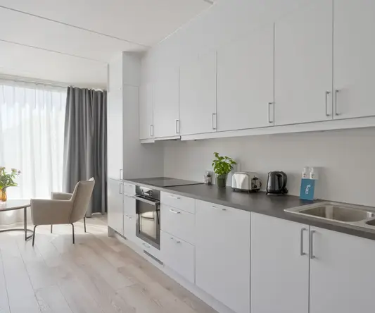 a kitchen with white cabinets and a wood floor